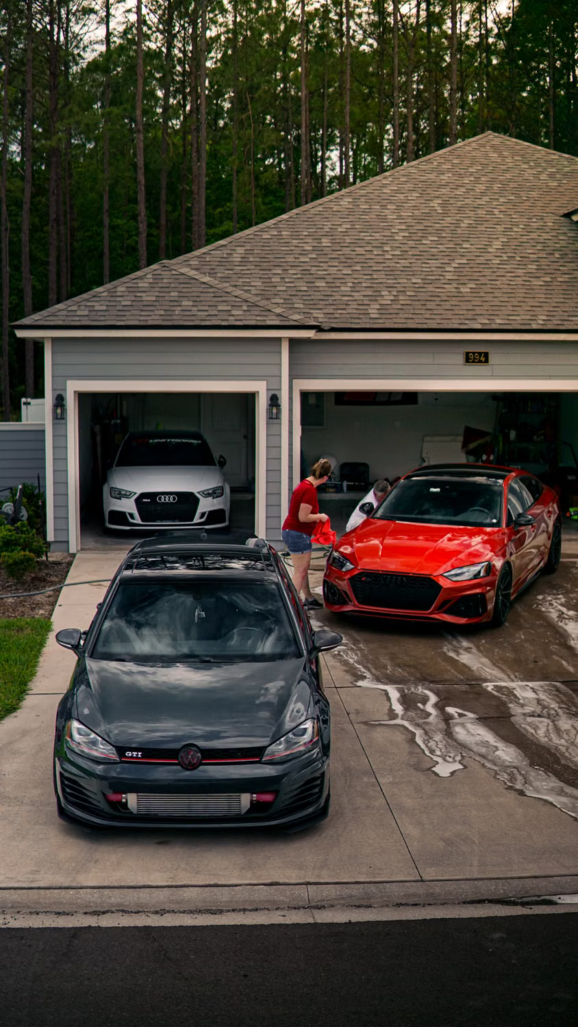 Vehicles being hand dried on a wet driveway after a detail